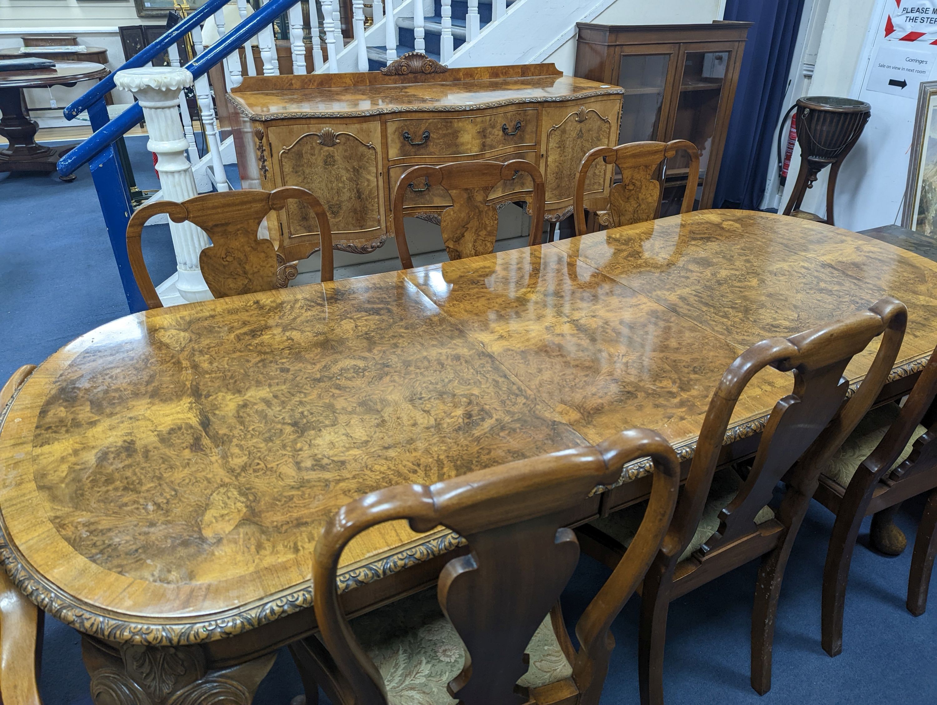 A Queen Anne revival burr walnut dining suite, comprising serpentine sideboard, length 168cm, depth 56cm, height 98cm, extending dining table, 210cm extended, one spare leaf, width 90cm, height 75cm and eight chairs, two